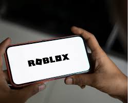 Roblox logo displayed on a smartphone screen. Roblox safety concerns | PGN Business Insider
