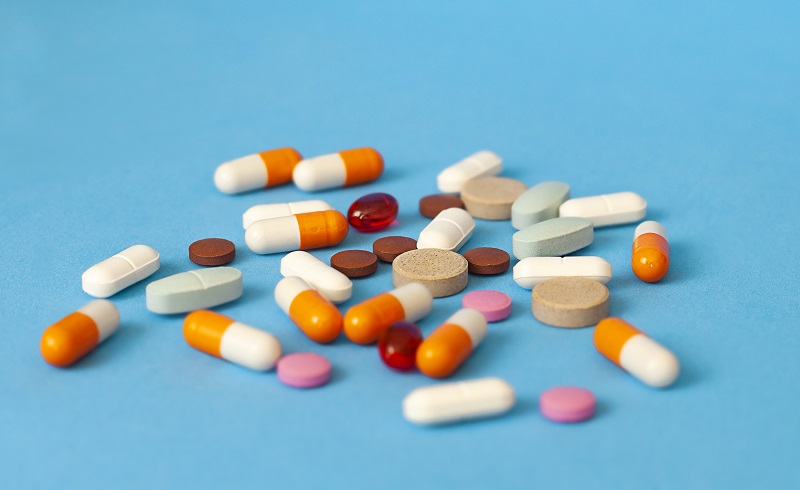 pills are scattered on a blue background | US-India tariffs | PGN Business Insider