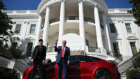Elon Musk y Donald Trump hablando junto a un Tesla Model S | PGN Business Insider