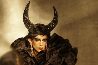 Arrastre artista Zeeshan Ali una pose, mientras llevaba una negrita negro peluca dramática con cuernos.