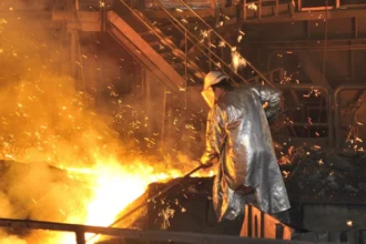 Steelworker en el reino unido de acero planta de utilizar el equipo de protección