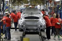 Worker assembling car keys at a manufacturing plant. | UK car production | PGN Business Insider | pottersgallerynigeria.org