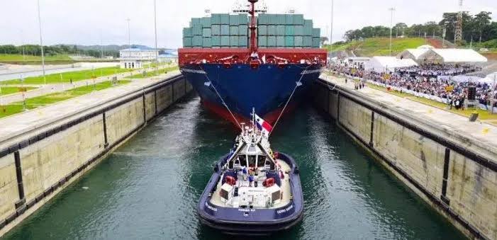 Buque de carga de navegar por el Canal de Panamá, con la asistencia de remolcador