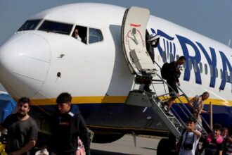 Pasajeros desembarcando de un avión de Ryanair bajo un cielo nublado