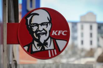 Restaurante KFC en el escaparate con el Coronel Sanders y el logotipo de pollo frito de señalización.