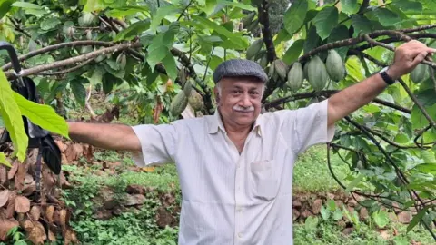 Dr. George Matthew in his cocoa plantation in Kerala, India.