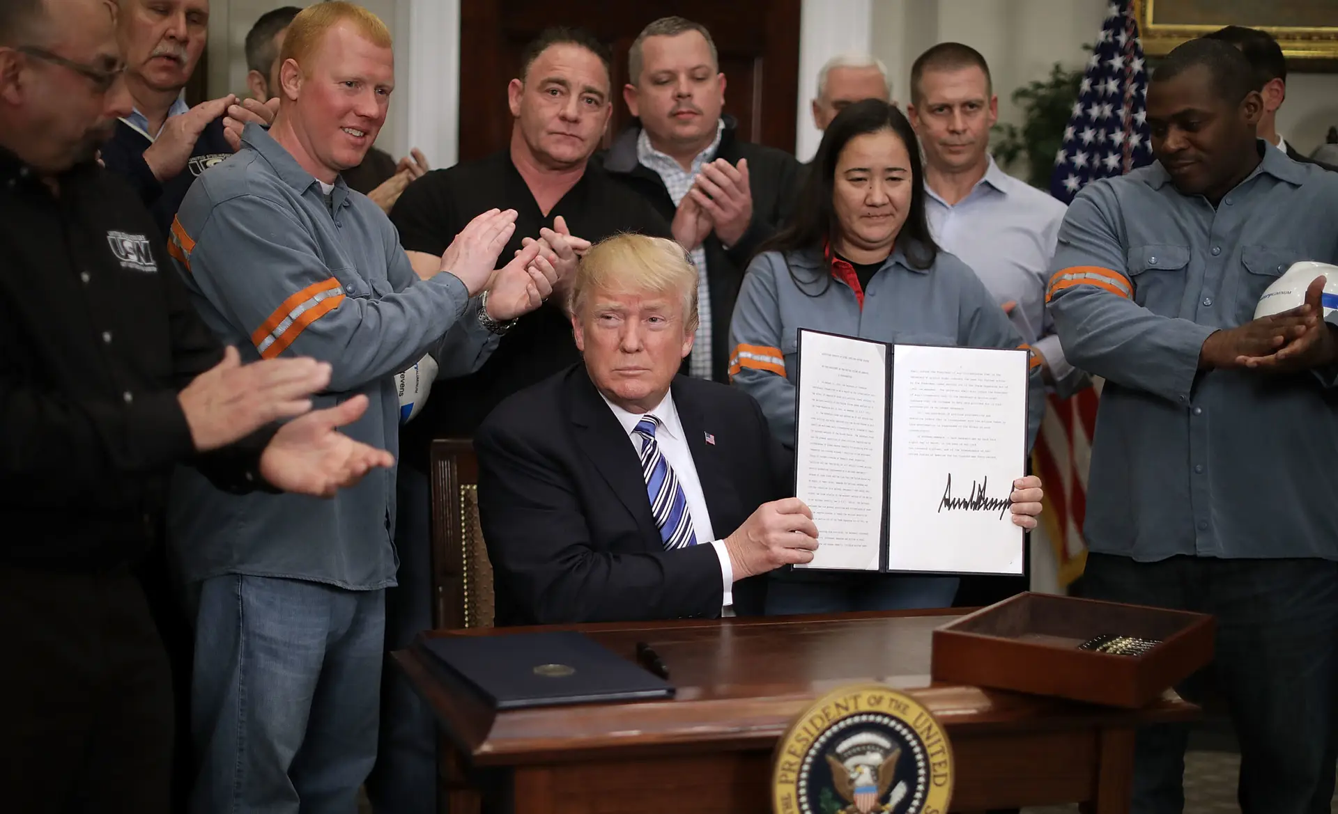 Donald Trump holding tariff orders.