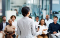 A confident CEO delivering a presentation to a diverse group of employees.