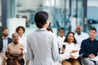 A confident CEO delivering a presentation to a diverse group of employees.