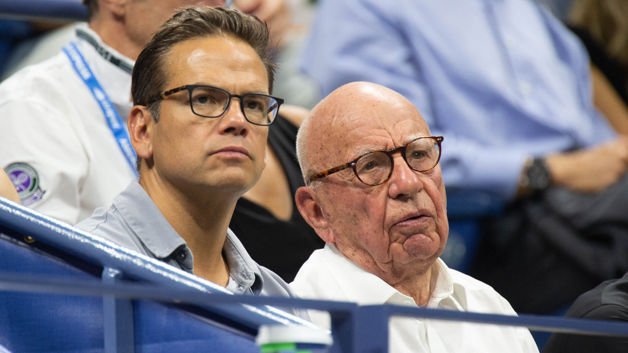 Rupert Murdoch and his son Lachlan seated together, clapping during the 2018 US Open tennis match.