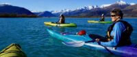 Kayakers on a lake with mountain backdrop in NZ