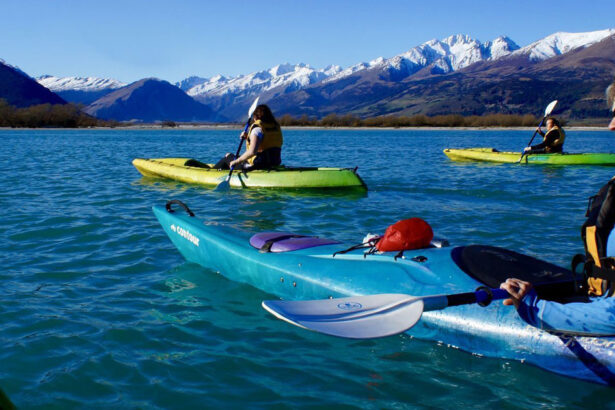 Kayakers on a lake with mountain backdrop in NZ