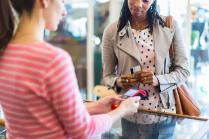 A woman pays for goods in a shop using a debit card | Trump's tariffs