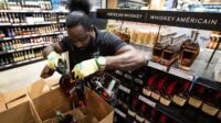 A worker removes bottles of American-made Jack Daniel's whiskey from a shelf at an LCBO store in Toronto | Canadian alcohol boycott