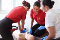 Cabin crew member administering first aid during an in-flight medical emergency to prevent In-flight death.