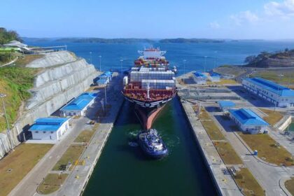 Cargo ship navigating the Panama Canal with tugboat assistance