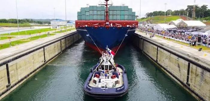 Cargo ship navigating the Panama Canal with tugboat assistance