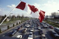 Cars on a highway with a Canadian flag | Car tariffs