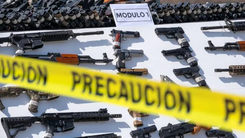 Recovered guns behind a yellow police tape | Mexico gun lawsuit