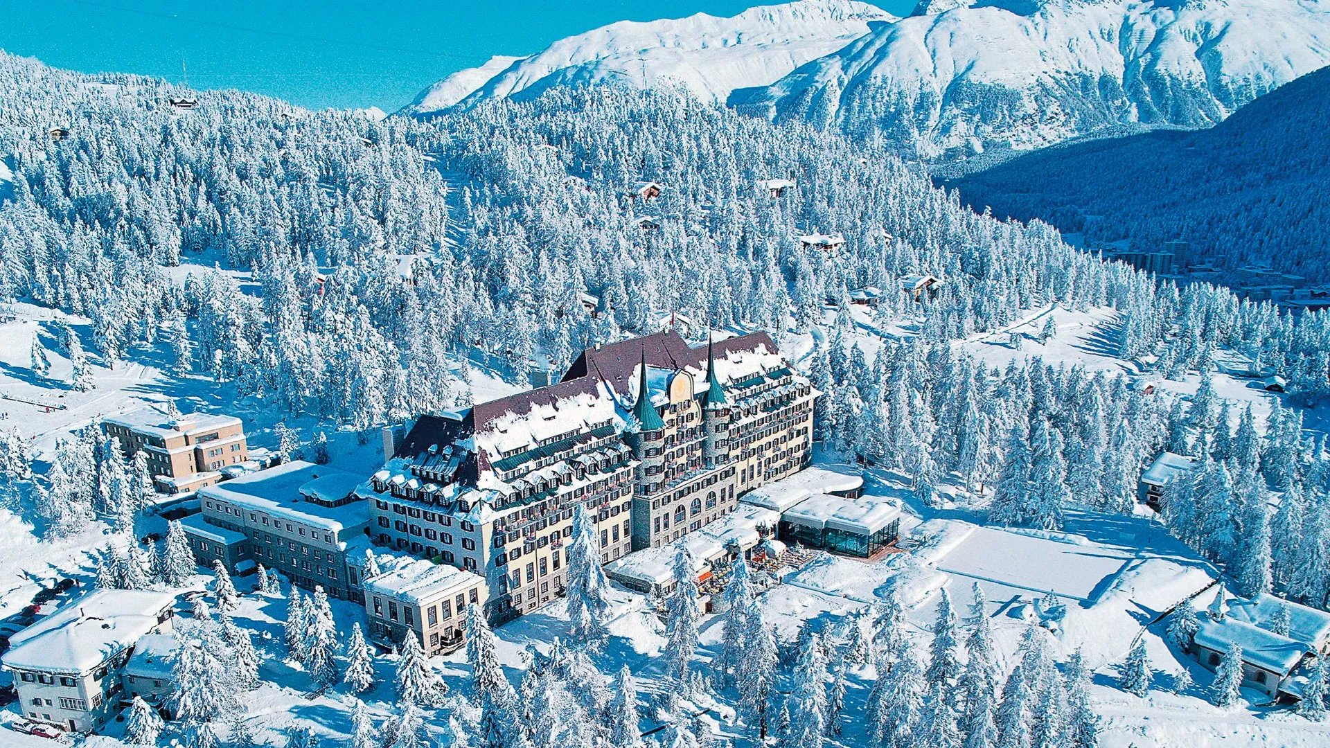 Swiss Alps luxury hotel with ski slopes in background | Switzerland luxury tourism