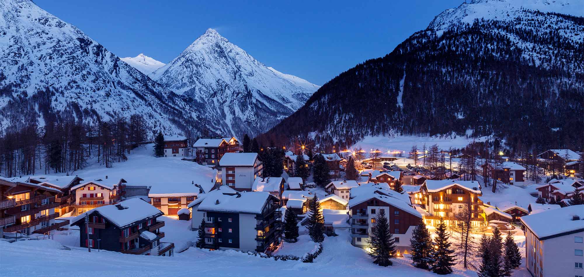 Swiss Alps luxury hotel with ski slopes in background | Switzerland luxury tourism